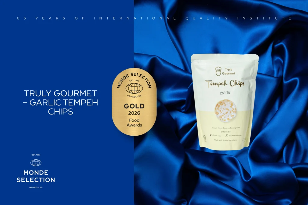 Truly Gourmet Garlic Tempeh Chips pack beside the Monde Selection Gold 2026 Food Awards badge